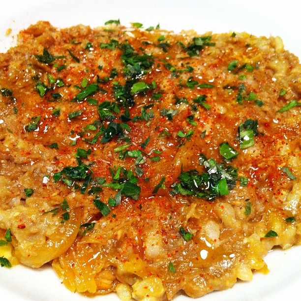 Mujadra topped with parsley, green onions, and cayenne